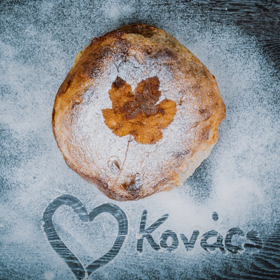 Scris cu făină pe blat: o inimă și numele Kovács